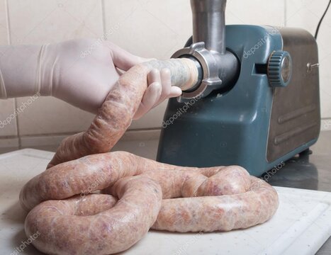 Metzger bereitet Bratwürste in einer sauberen Produktionsküche zu