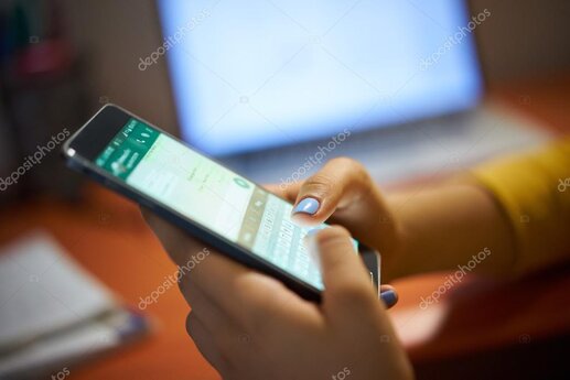 Smartphone mit WhatsApp-Chat neben einem Teller mit Wurstwaren